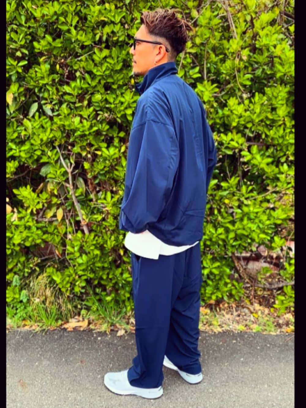 ブルー系のナイロンジャケット、ブルー系のその他パンツ、グレー系のスニーカーを着用したメンズの春コーディネートの3枚目の写真