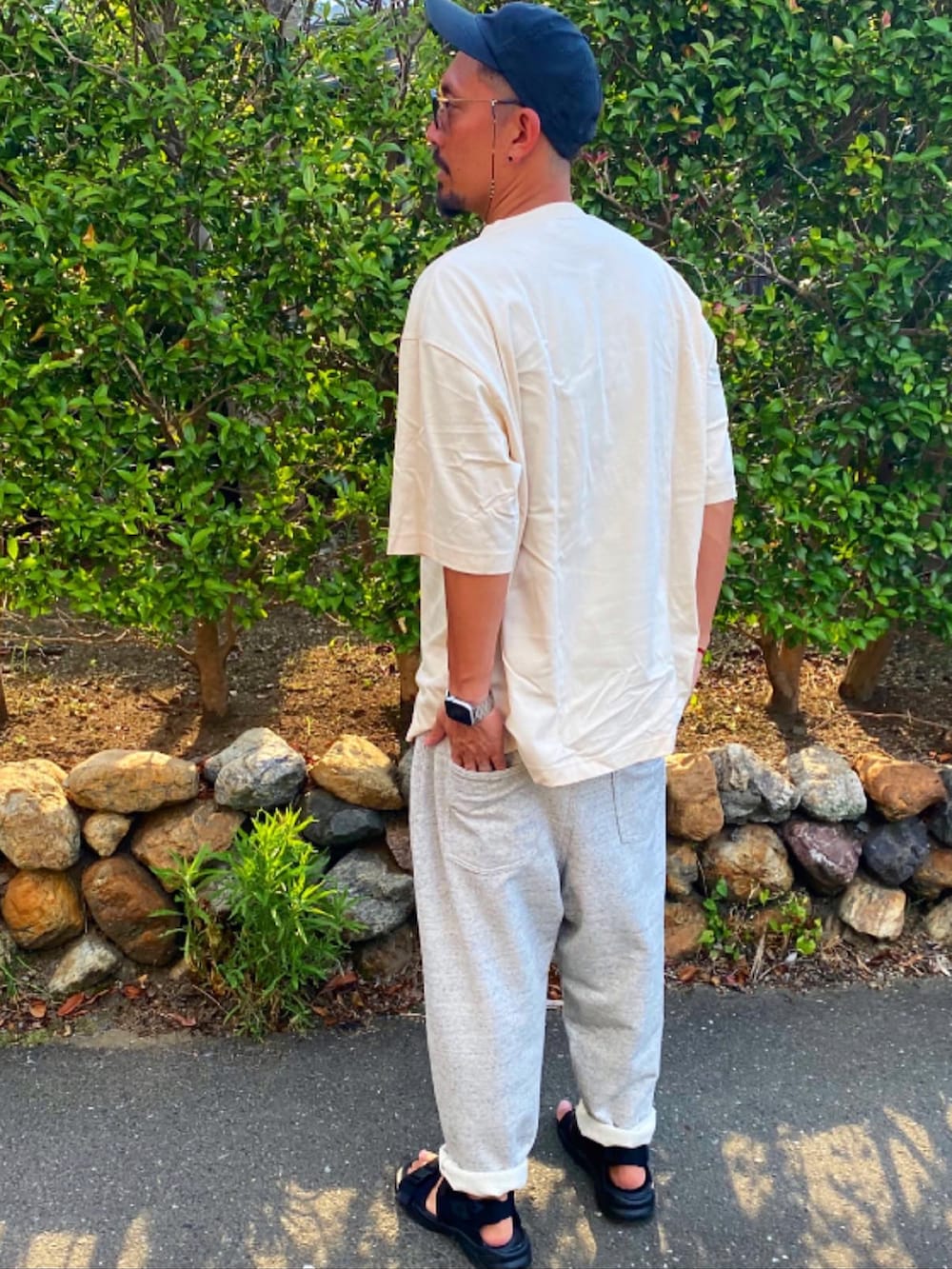 ブラック系のTシャツ/カットソー、シルバー系のスウェットパンツ、ブラック系のサンダルを着用したメンズの夏コーディネートの3枚目の写真