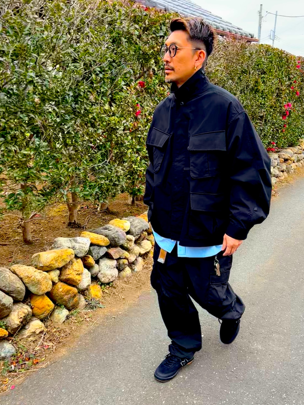 ブラック系のミリタリージャケット、ブルー系のシャツ/ブラウス、ブラック系のカーゴパンツを着用したメンズの冬コーディネートの2枚目の写真