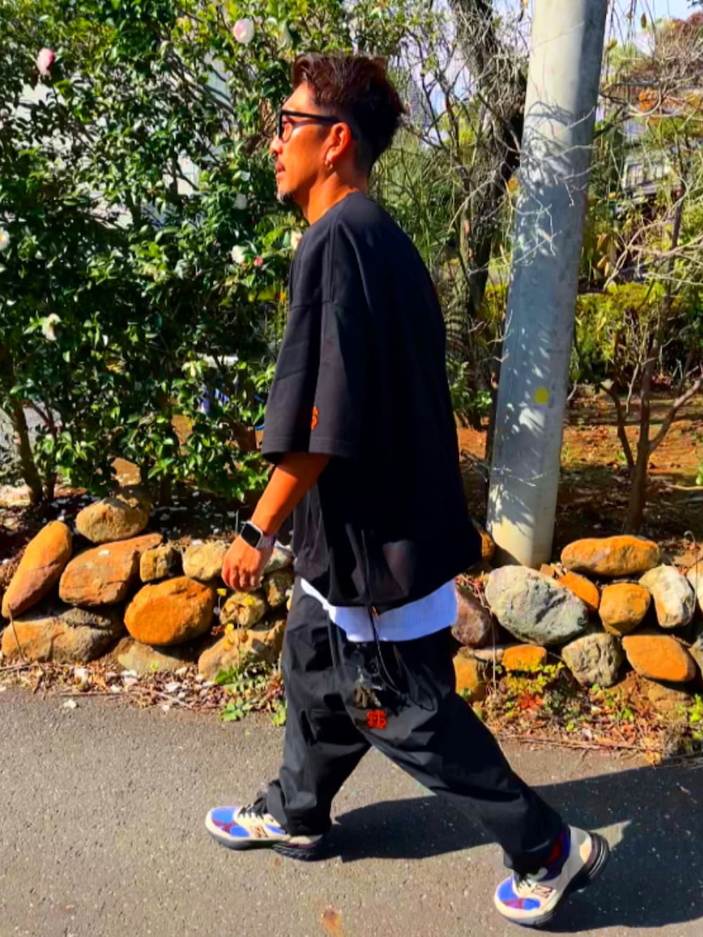 ブラック系のTシャツ/カットソー、ブラック系のその他パンツ、ホワイト系のスニーカーを着用したメンズの秋コーディネートの4枚目の写真