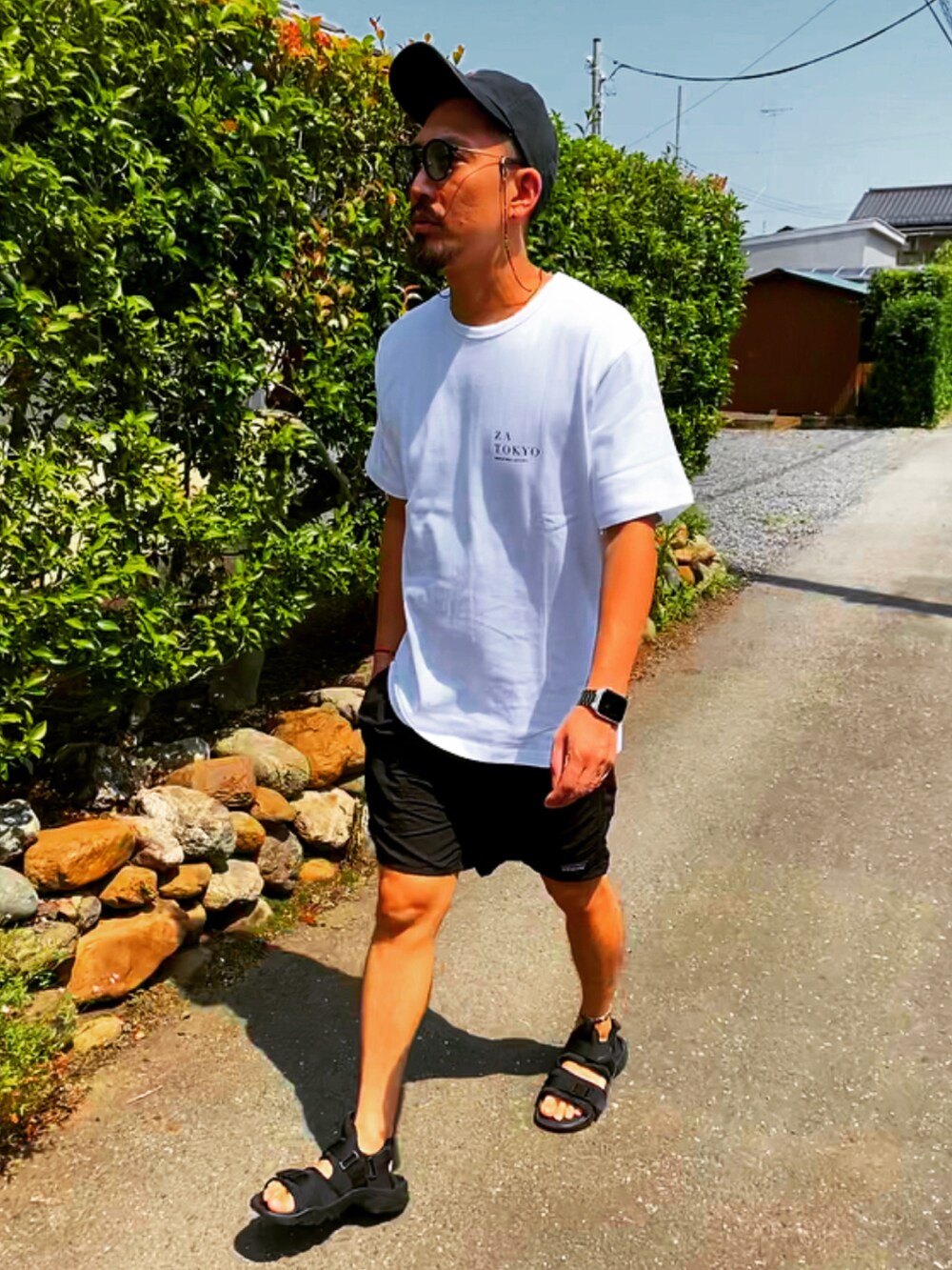 ホワイト系のTシャツ/カットソー、ブラック系のその他パンツ、ブラック系のサンダルを着用したメンズの夏コーディネートの3枚目の写真
