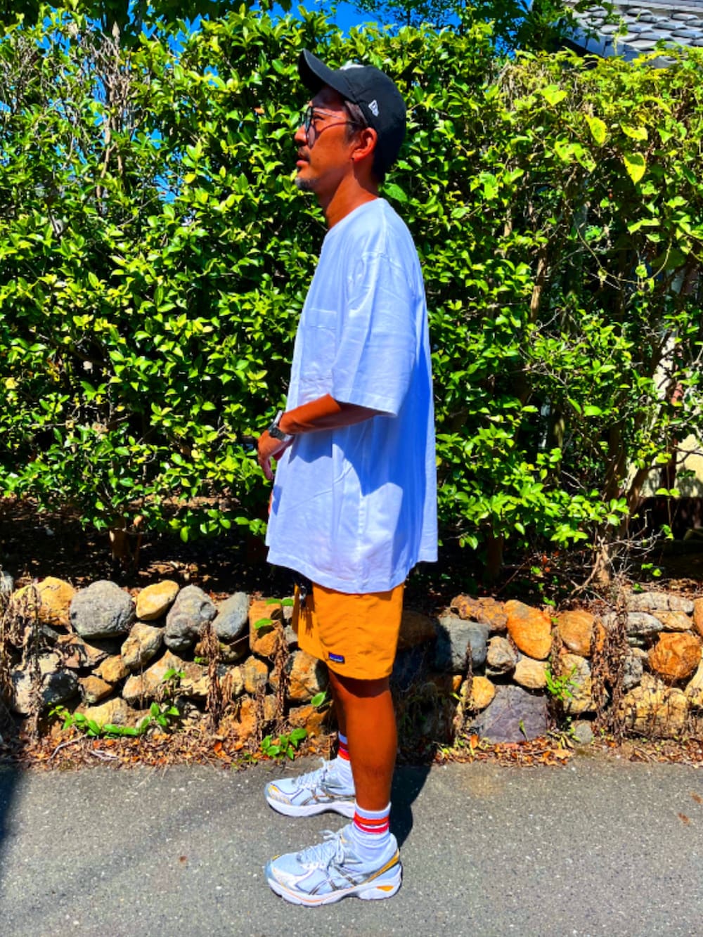 ホワイト系のTシャツ/カットソー、イエロー系のその他パンツ、シルバー系のスニーカーを着用したメンズの夏コーディネートの4枚目の写真