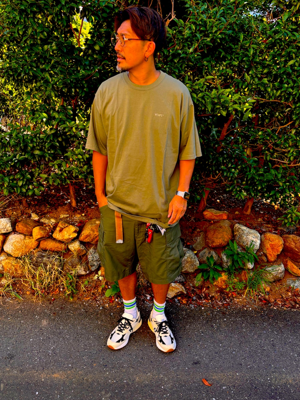 グリーン系のTシャツ/カットソー、グリーン系のその他パンツ、ホワイト系のスニーカーを着用したメンズの夏コーディネートの2枚目の写真