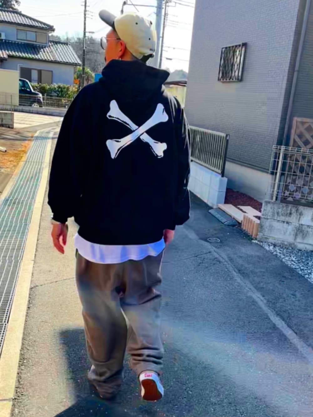 ブラック系のパーカー、ホワイト系のTシャツ/カットソー、ベージュ系のスウェットパンツを着用したメンズの春コーディネートの5枚目の写真