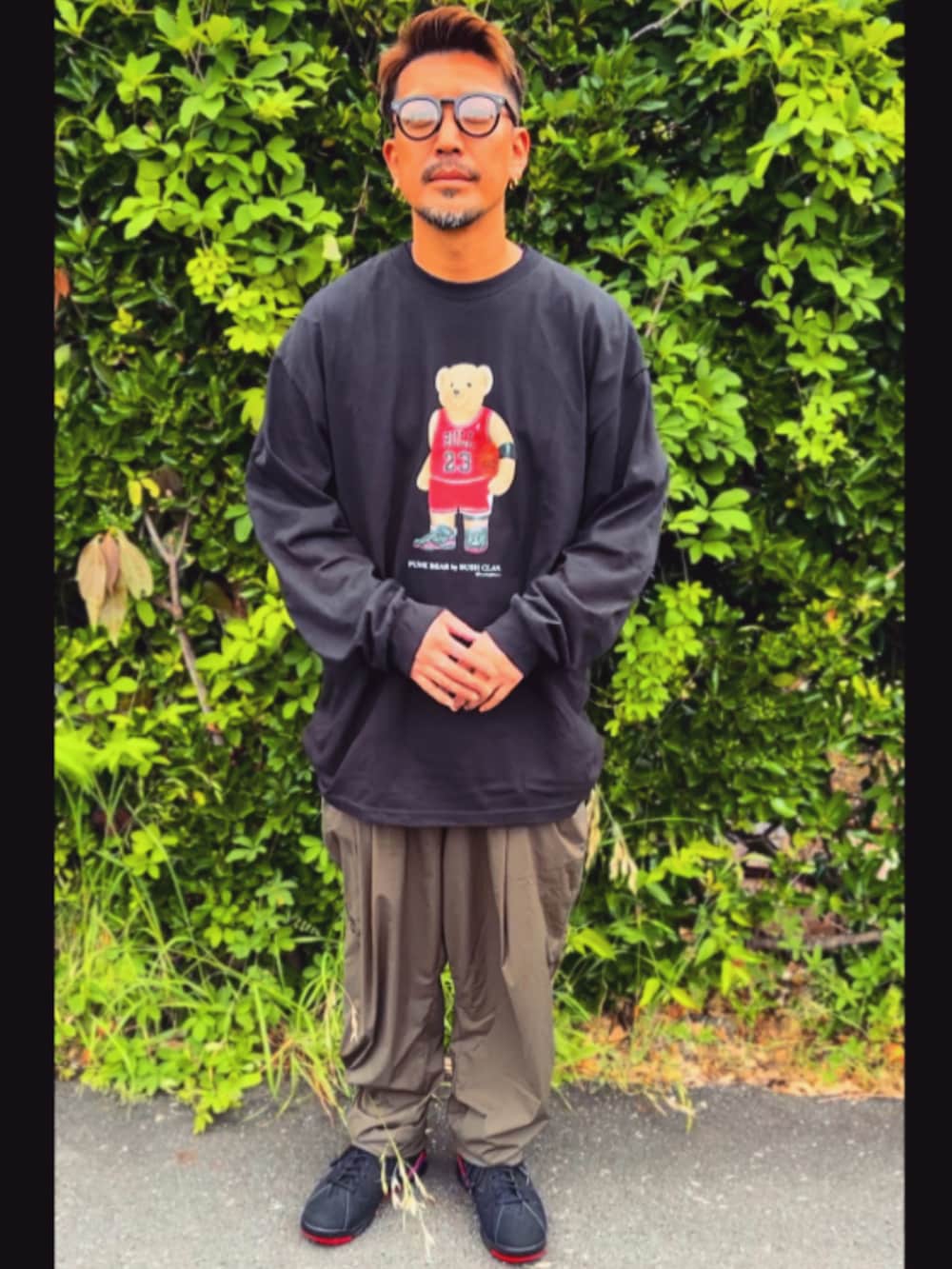 ブラック系のTシャツ/カットソー、グリーン系のその他パンツ、ブラック系のスニーカーを着用したメンズの春コーディネートの3枚目の写真