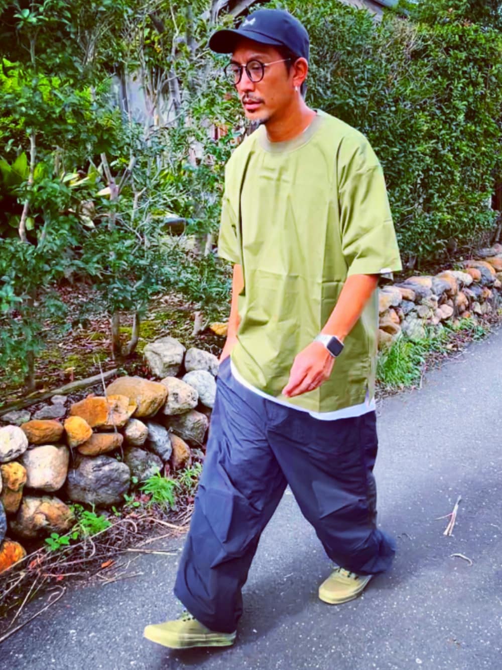 グリーン系のTシャツ/カットソー、ブラック系のその他パンツ、グリーン系のスニーカーを着用したメンズの秋コーディネートの4枚目の写真