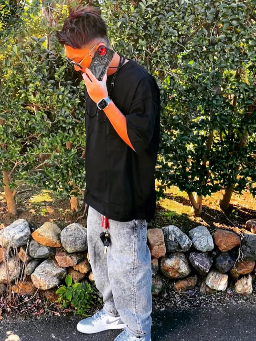 ブラック系のTシャツ/カットソー、グレー系のデニムパンツ、グレー系のスニーカーを着用したメンズの秋コーディネートの4枚目の写真