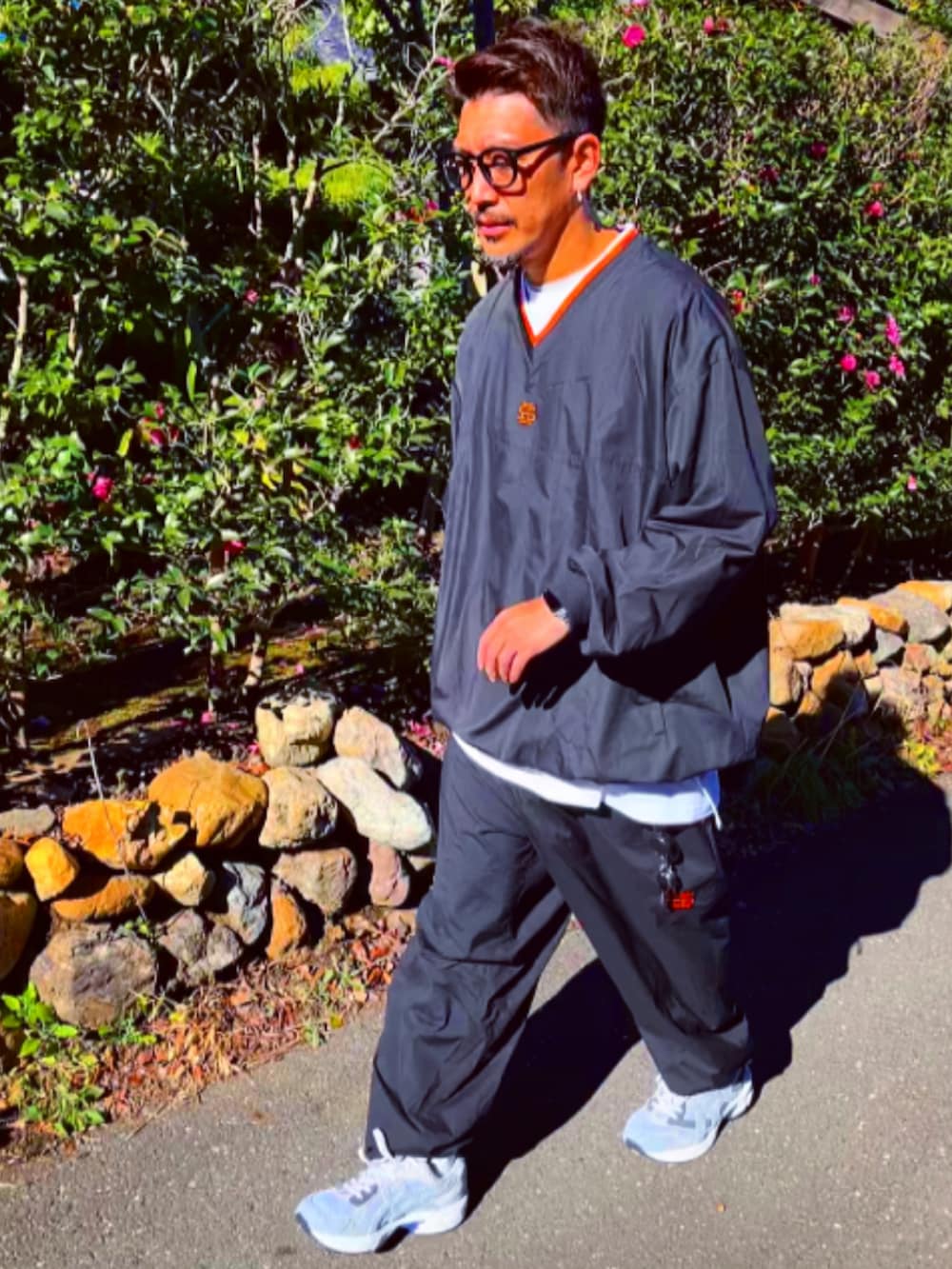 ブラック系のナイロンジャケット、ブラック系のその他パンツ、ホワイト系のスニーカーを着用したメンズの冬コーディネートの3枚目の写真