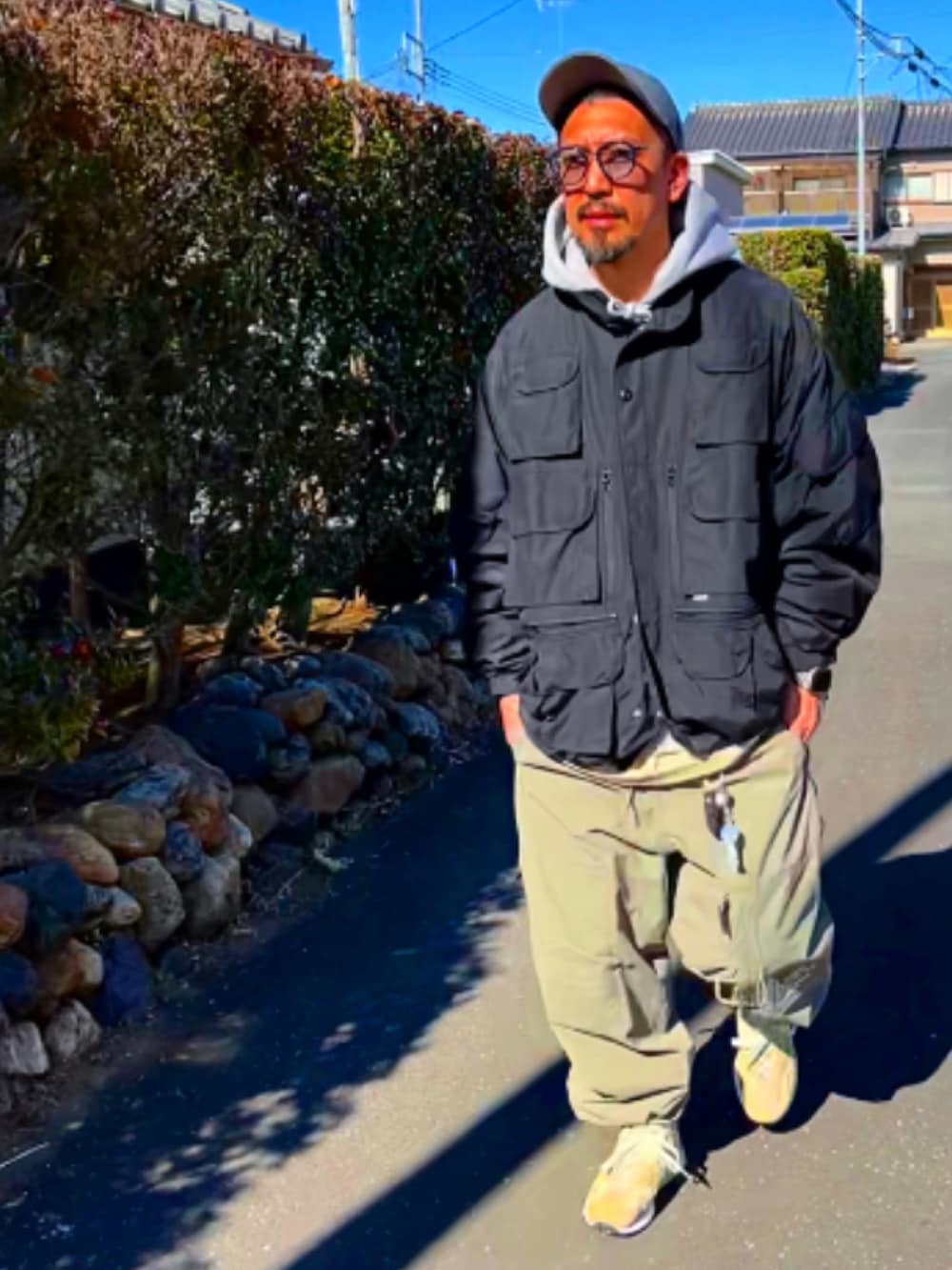 ブラック系のミリタリージャケット、グレー系のパーカー、グリーン系のその他パンツを着用したメンズの冬コーディネートの3枚目の写真