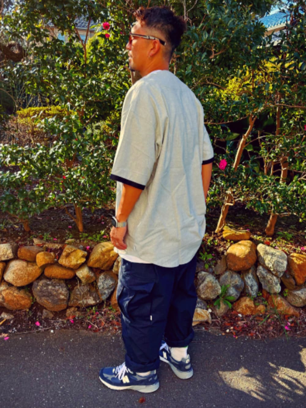 グレー系のTシャツ/カットソー、ブルー系のカーゴパンツ、ブルー系のスニーカーを着用したメンズの秋コーディネートの3枚目の写真