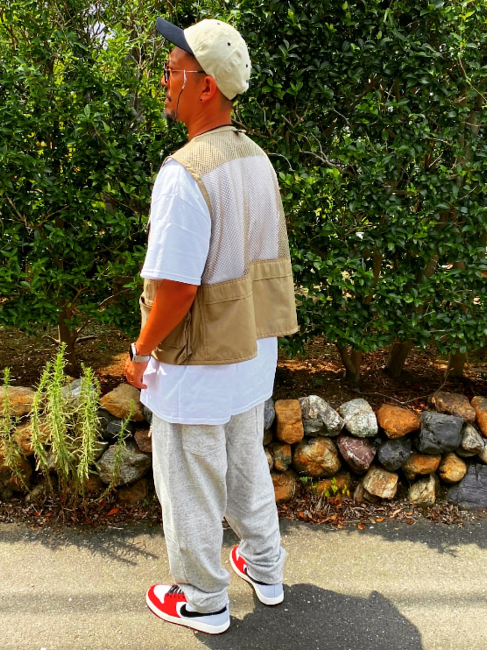 ベージュ系のベスト、ホワイト系のTシャツ/カットソー、シルバー系のスウェットパンツを着用したメンズの春コーディネートの3枚目の写真