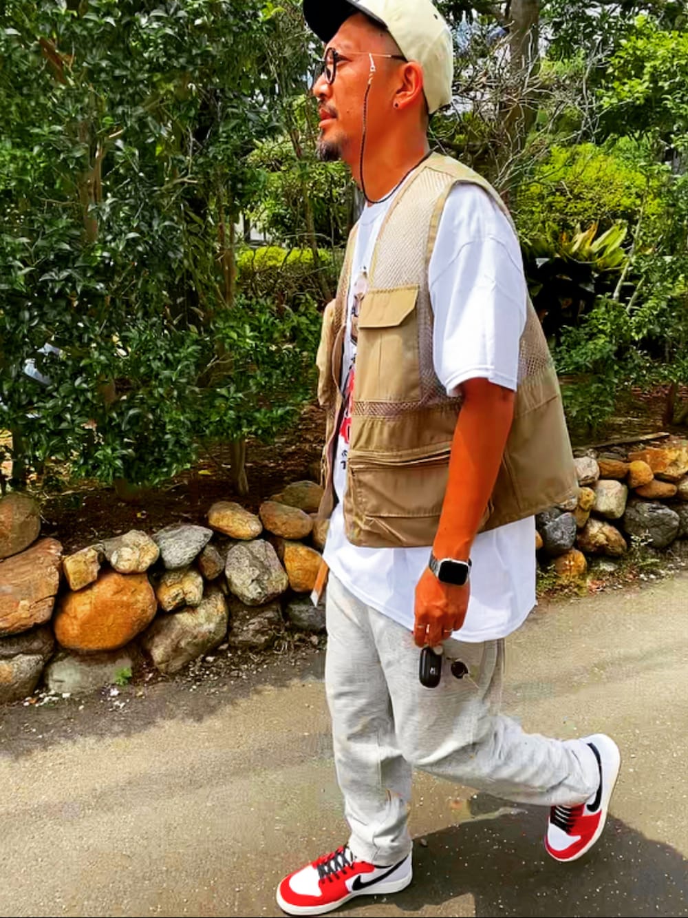 ベージュ系のベスト、ホワイト系のTシャツ/カットソー、シルバー系のスウェットパンツを着用したメンズの春コーディネートの5枚目の写真