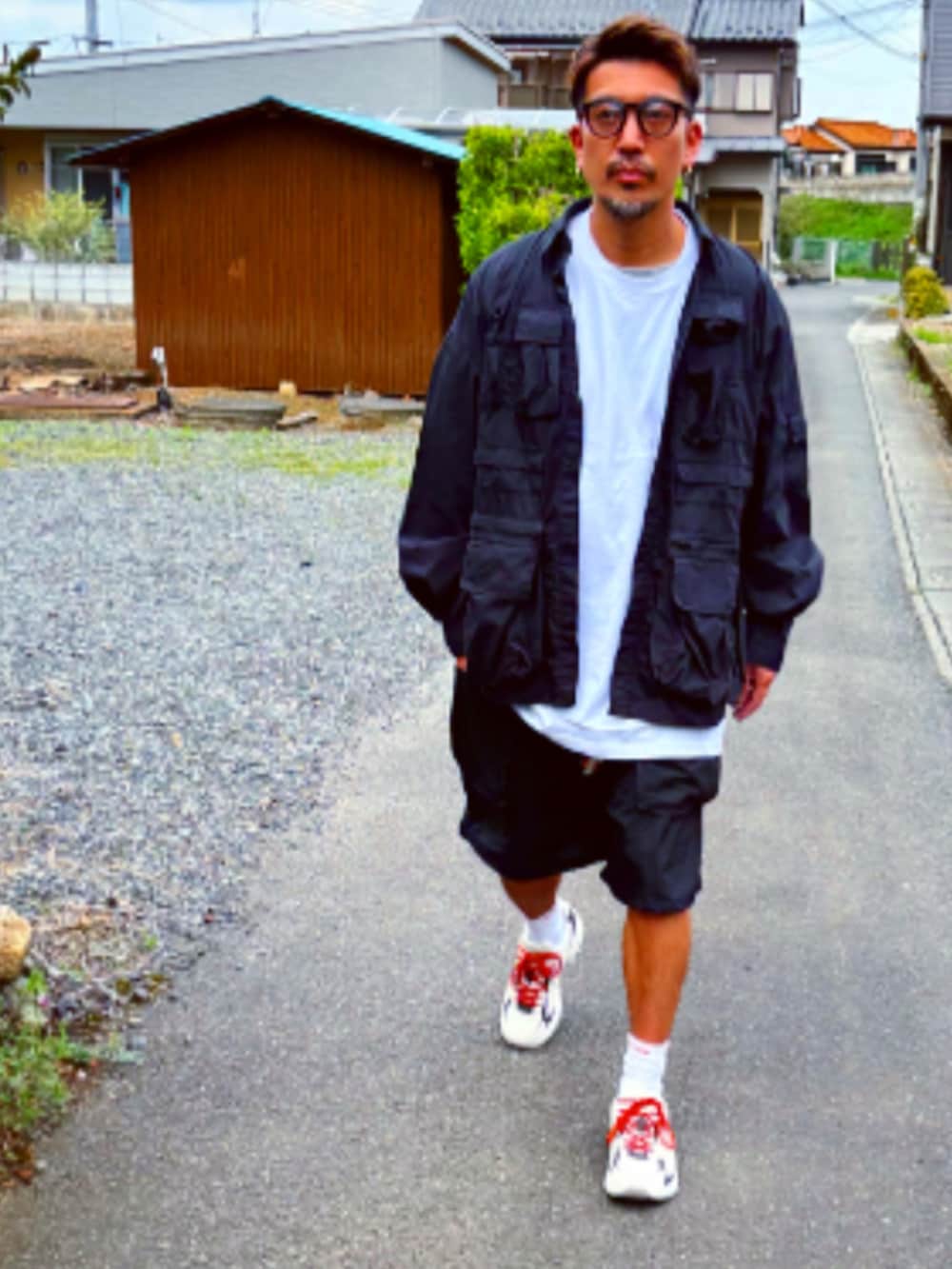 ブラック系のミリタリージャケット、ブラック系のTシャツ/カットソー、ブラック系のカーゴパンツを着用したメンズの春コーディネートの3枚目の写真