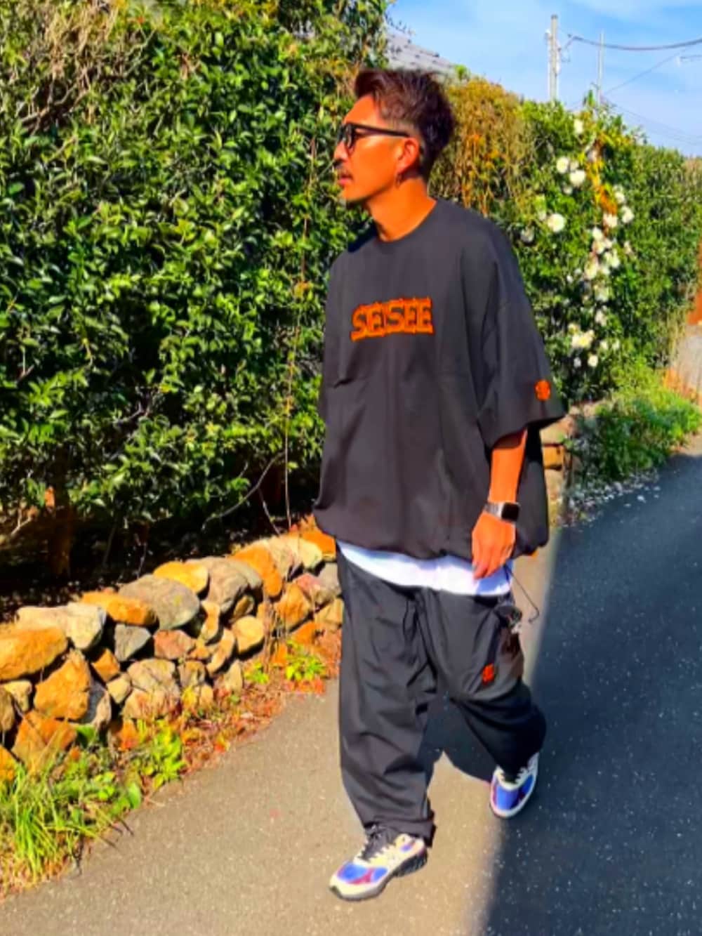 ブラック系のTシャツ/カットソー、ブラック系のその他パンツ、ホワイト系のスニーカーを着用したメンズの秋コーディネートの2枚目の写真