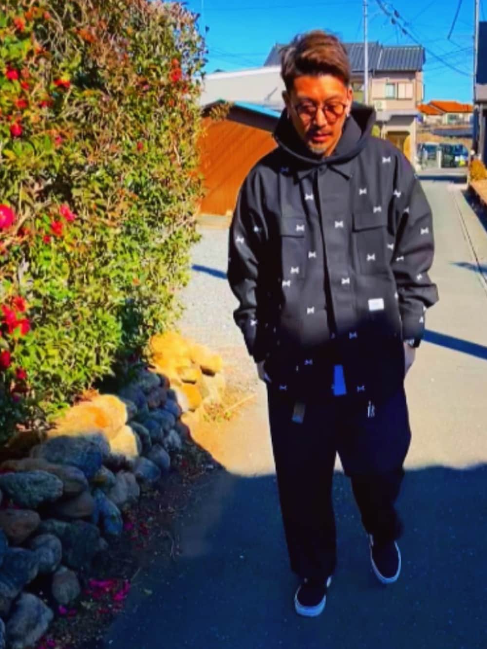 ブラック系のジャケット/アウター、ブラック系のパーカー、レッド系のチノパンツを着用したメンズの冬コーディネートの2枚目の写真