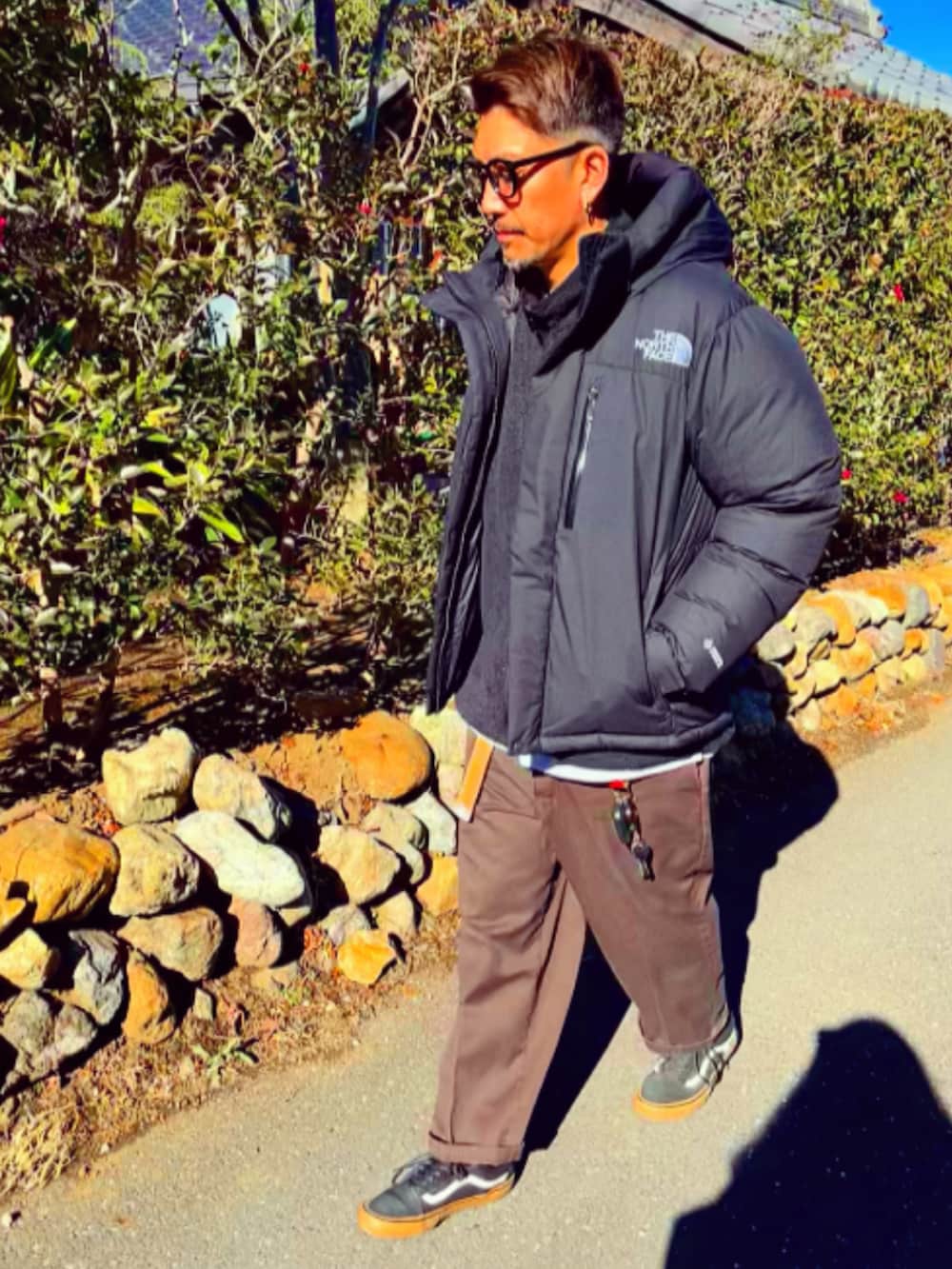 ブラック系のダウンジャケット/コート、ブラック系のナイロンジャケット、レッド系のチノパンツを着用したメンズの冬コーディネートの3枚目の写真