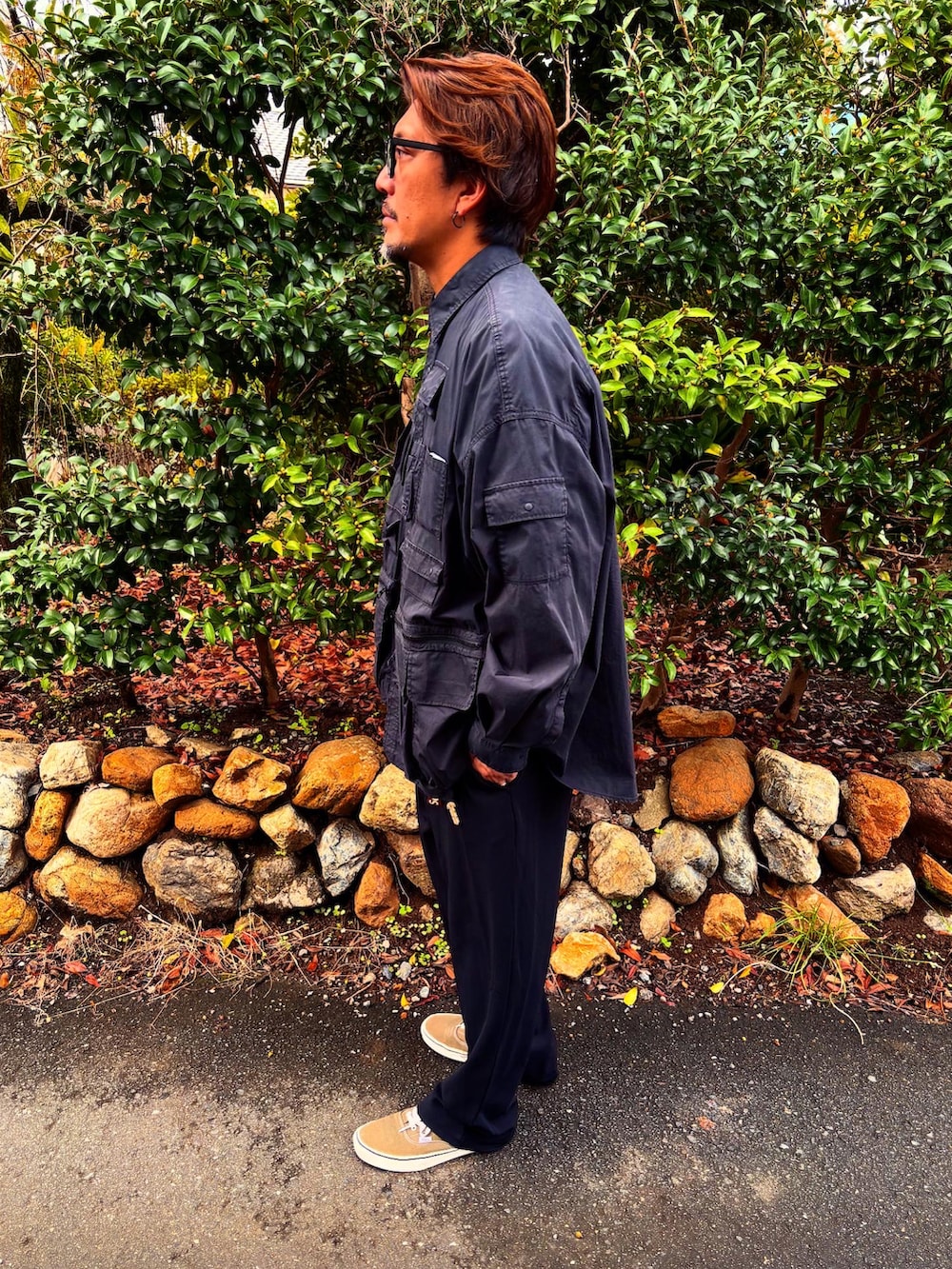 グレー系のTシャツ/カットソー、ベージュ系のスニーカー、ブラック系のミリタリージャケットを着用したメンズの秋コーディネートの3枚目の写真