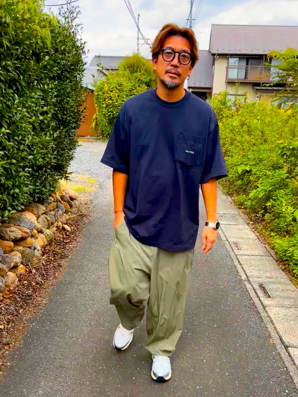 ブルー系のTシャツ/カットソー、グリーン系のその他パンツ、ブラック系のスニーカーを着用したメンズの秋コーディネートの4枚目の写真