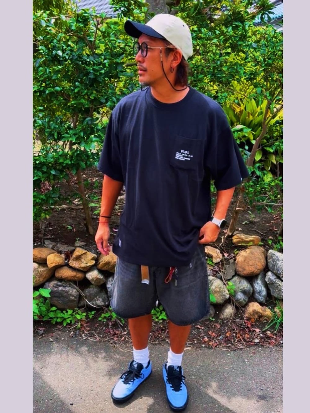 ブラック系のデニムパンツ、ブラック系のTシャツ/カットソー、ブルー系のスニーカーを着用したメンズの秋コーディネートの2枚目の写真
