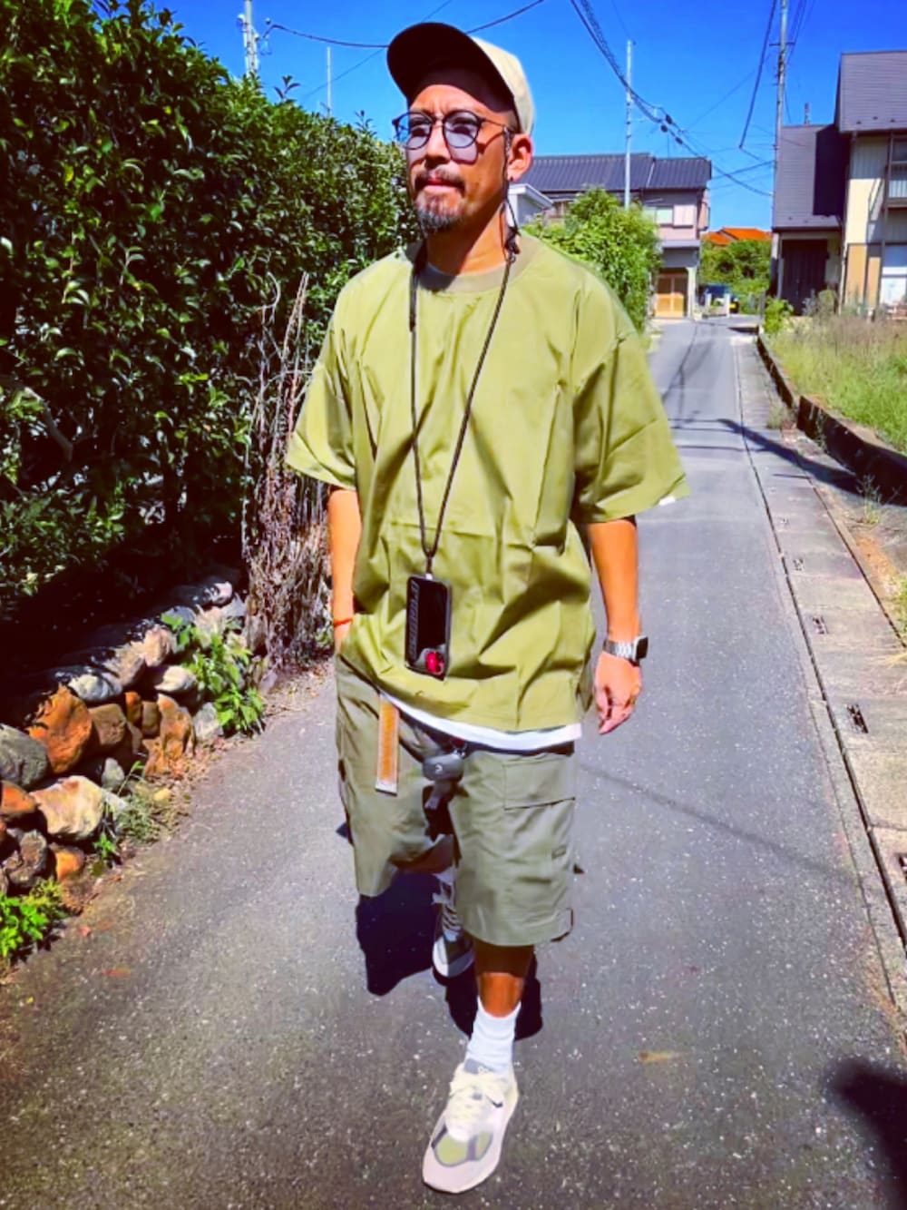 グリーン系のTシャツ/カットソー、グリーン系のその他パンツ、グレー系のスニーカーを着用したメンズの秋コーディネートの2枚目の写真