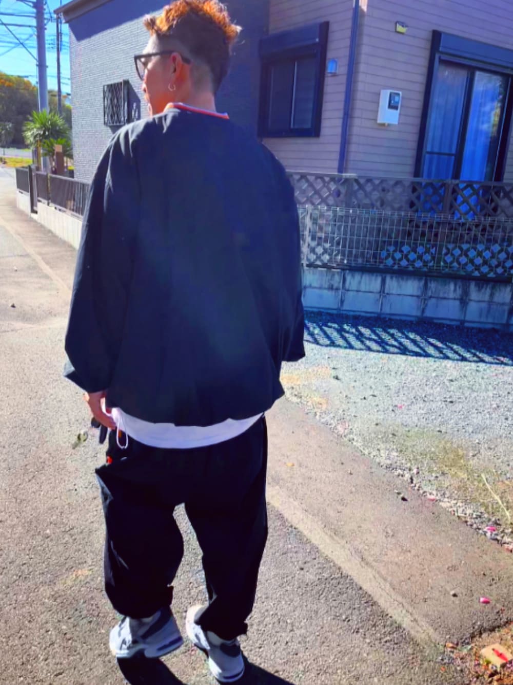 ブラック系のナイロンジャケット、ブラック系のその他パンツ、ホワイト系のスニーカーを着用したメンズの冬コーディネートの5枚目の写真