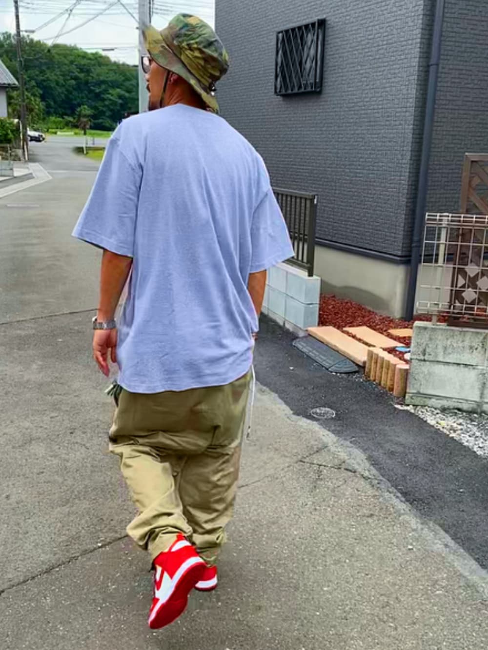 グレー系のTシャツ/カットソー、ベージュ系のその他パンツ、レッド系のスニーカーを着用したメンズの夏コーディネートの5枚目の写真