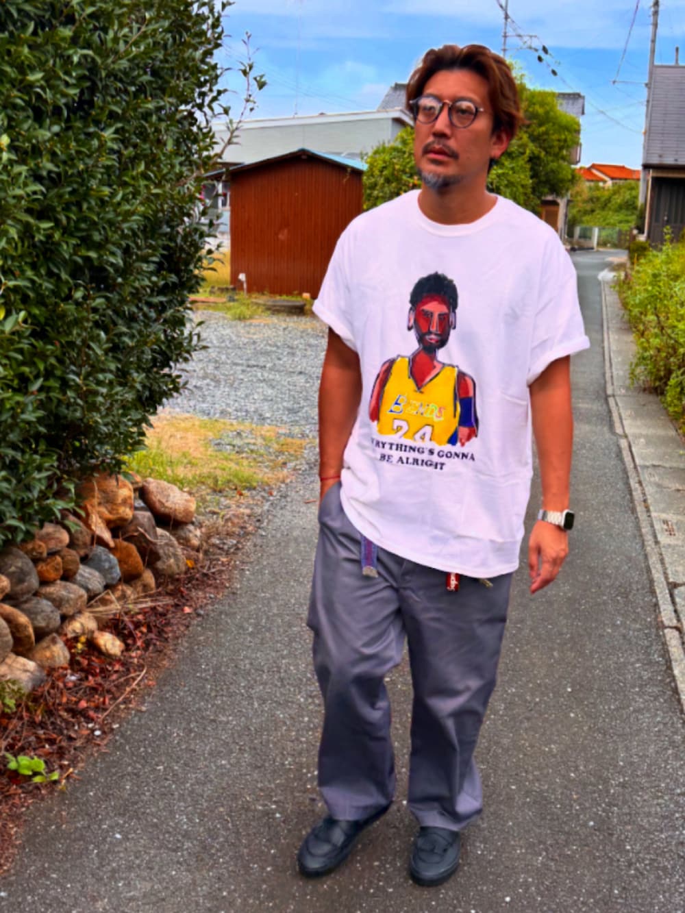 グレー系のチノパンツ、ブラック系のスニーカー、ホワイト系のTシャツ/カットソーを着用したメンズの秋コーディネートの2枚目の写真