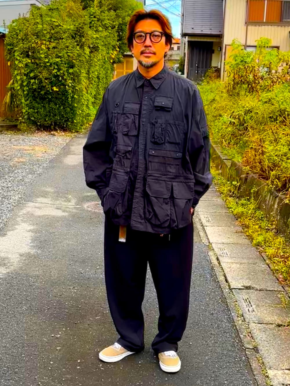 グレー系のTシャツ/カットソー、ベージュ系のスニーカー、ブラック系のミリタリージャケットを着用したメンズの秋コーディネートの5枚目の写真