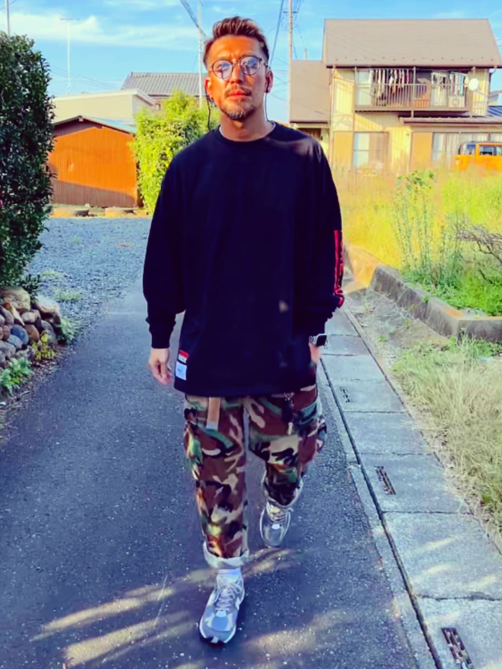 ブラック系のTシャツ/カットソー、その他のカーゴパンツ、グレー系のスニーカーを着用したメンズの秋コーディネートの4枚目の写真