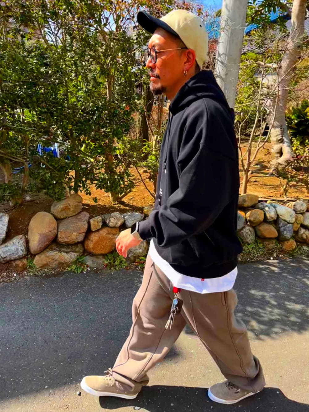 ブラック系のパーカー、ホワイト系のTシャツ/カットソー、ベージュ系のスウェットパンツを着用したメンズの春コーディネートの4枚目の写真