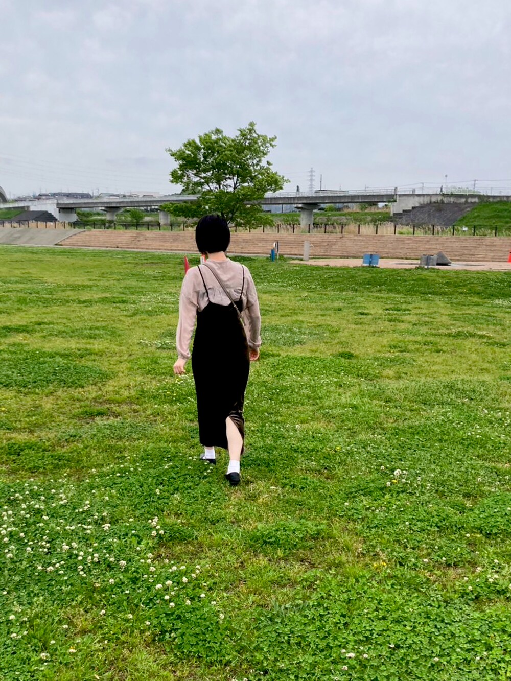 ベージュ系のシャツ/ブラウス、ベージュ系のショルダーバッグ、グリーン系のワンピースを着用したレディースの春コーディネートの2枚目の写真