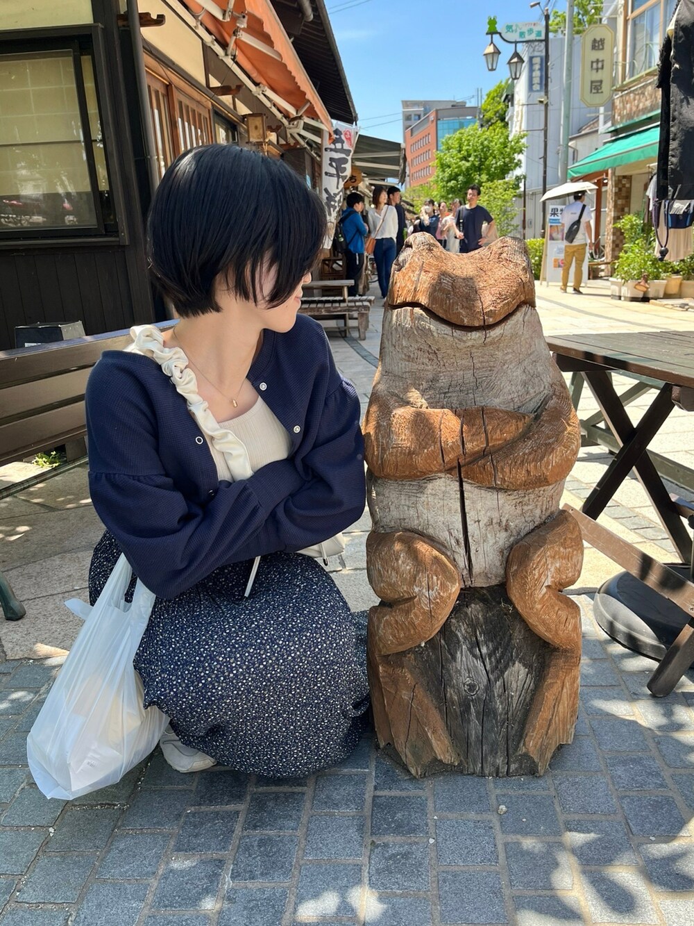 ベージュ系のタンクトップ、ブルー系のカーディガン/ボレロ、ブルー系のスカートを着用したレディースの春コーディネートの2枚目の写真