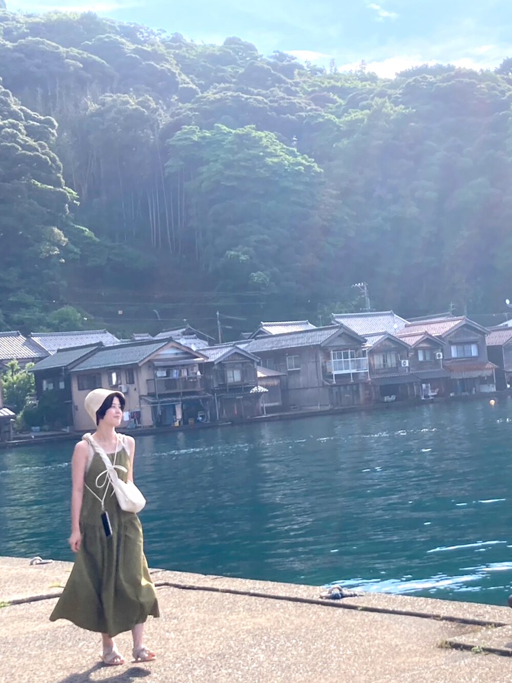 グリーン系のワンピース、ホワイト系のショルダーバッグを着用したレディースの夏コーディネートの2枚目の写真