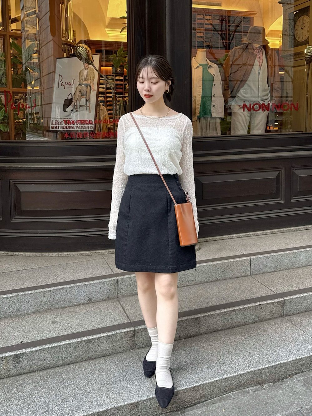 ホワイト系のTシャツ/カットソー、ブラック系のデニムスカートを着用したレディースの春コーディネートの2枚目の写真