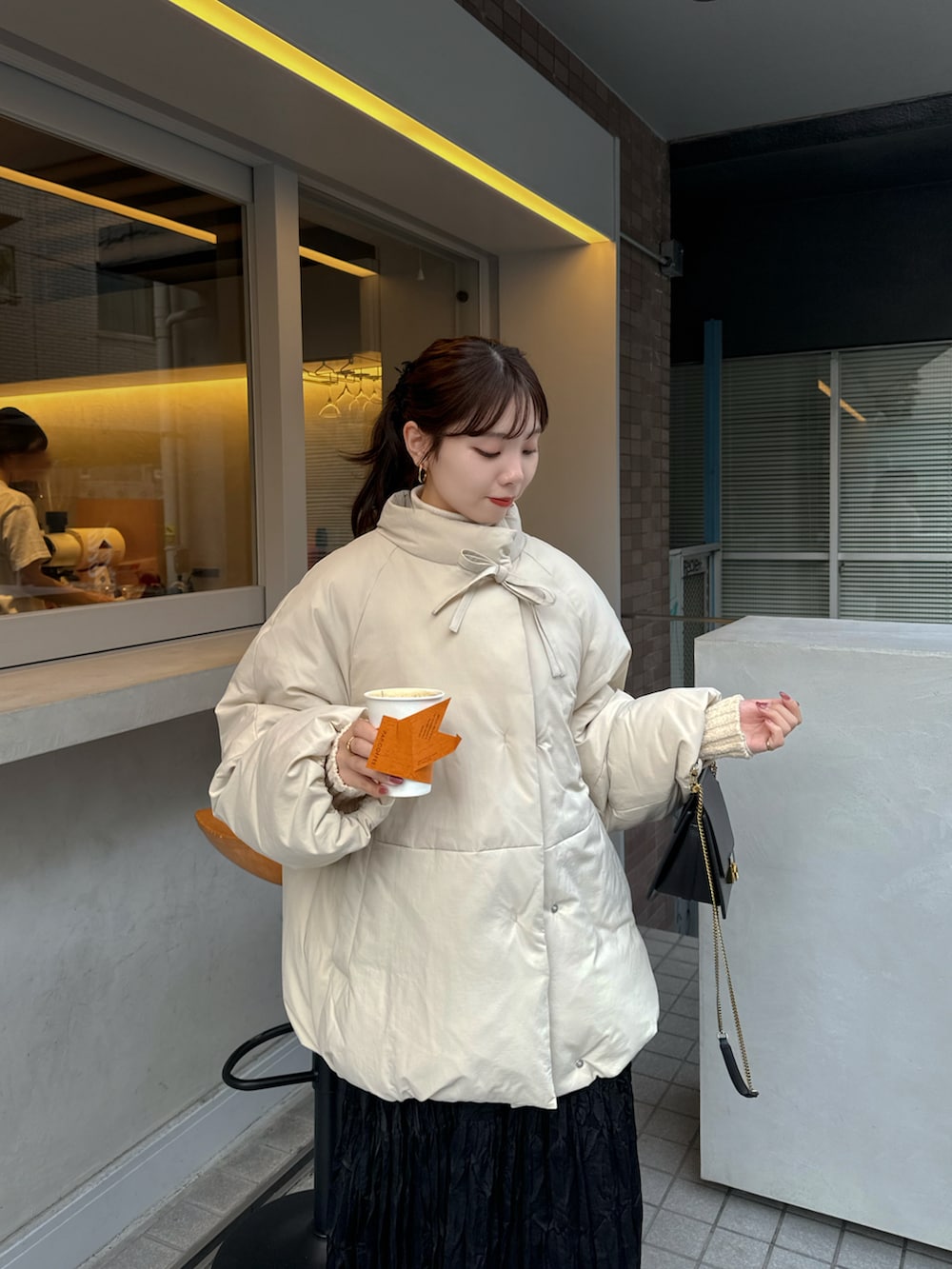 ベージュ系のブルゾン、ブラック系のスカートを着用したレディースの秋コーディネートの4枚目の写真