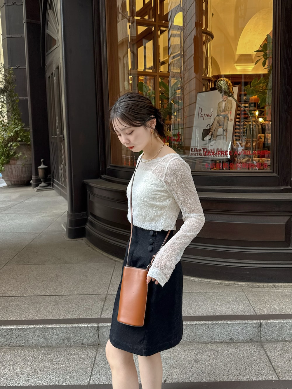 ホワイト系のTシャツ/カットソー、ブラック系のデニムスカートを着用したレディースの春コーディネートの4枚目の写真