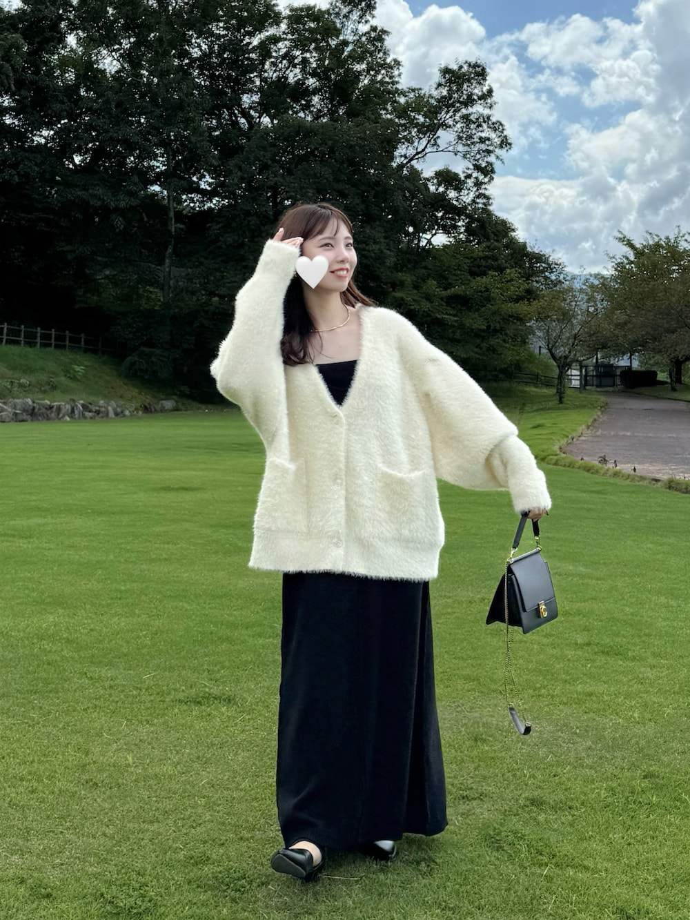 ホワイト系のカーディガン/ボレロ、ブラック系のワンピースを着用したレディースの秋コーディネートの2枚目の写真