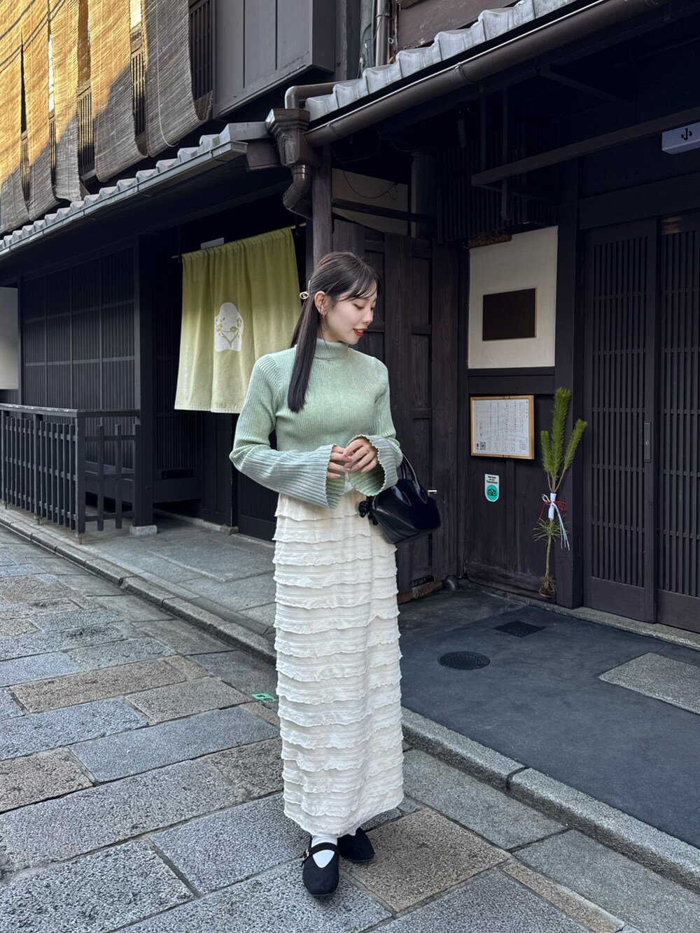 ベージュ系のその他アウター、グリーン系のニット/セーターを着用したレディースの冬コーディネートの3枚目の写真