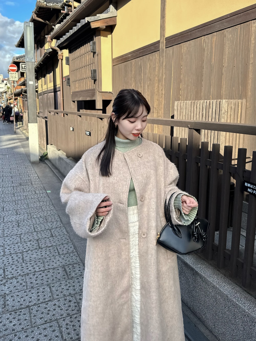 ベージュ系のその他アウター、グリーン系のニット/セーターを着用したレディースの冬コーディネートの2枚目の写真