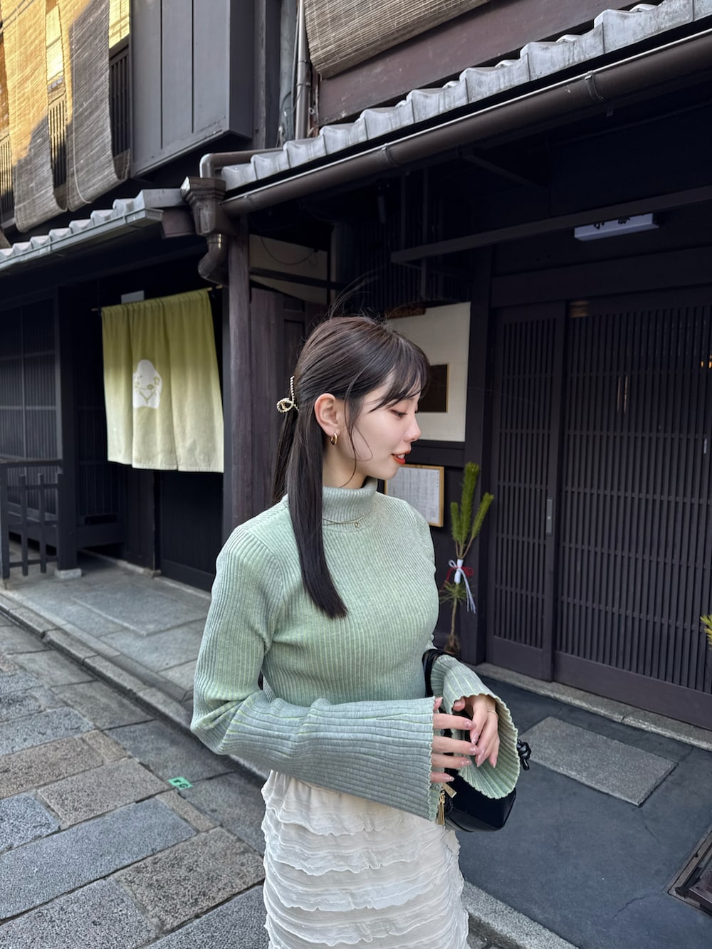 ベージュ系のその他アウター、グリーン系のニット/セーターを着用したレディースの冬コーディネートの4枚目の写真