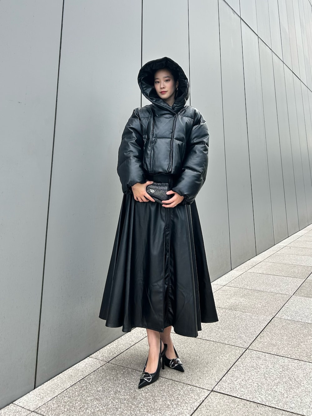 ブラック系のダウンジャケット/コート、ブラック系のショルダーバッグ、ブラック系のワンピースを着用したレディースの冬コーディネートの2枚目の写真