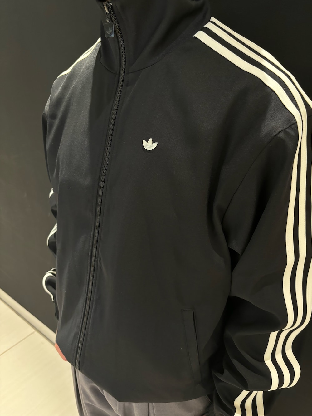 ブラック系のジャージ、ブルー系のスニーカーを着用したメンズの冬コーディネートの3枚目の写真