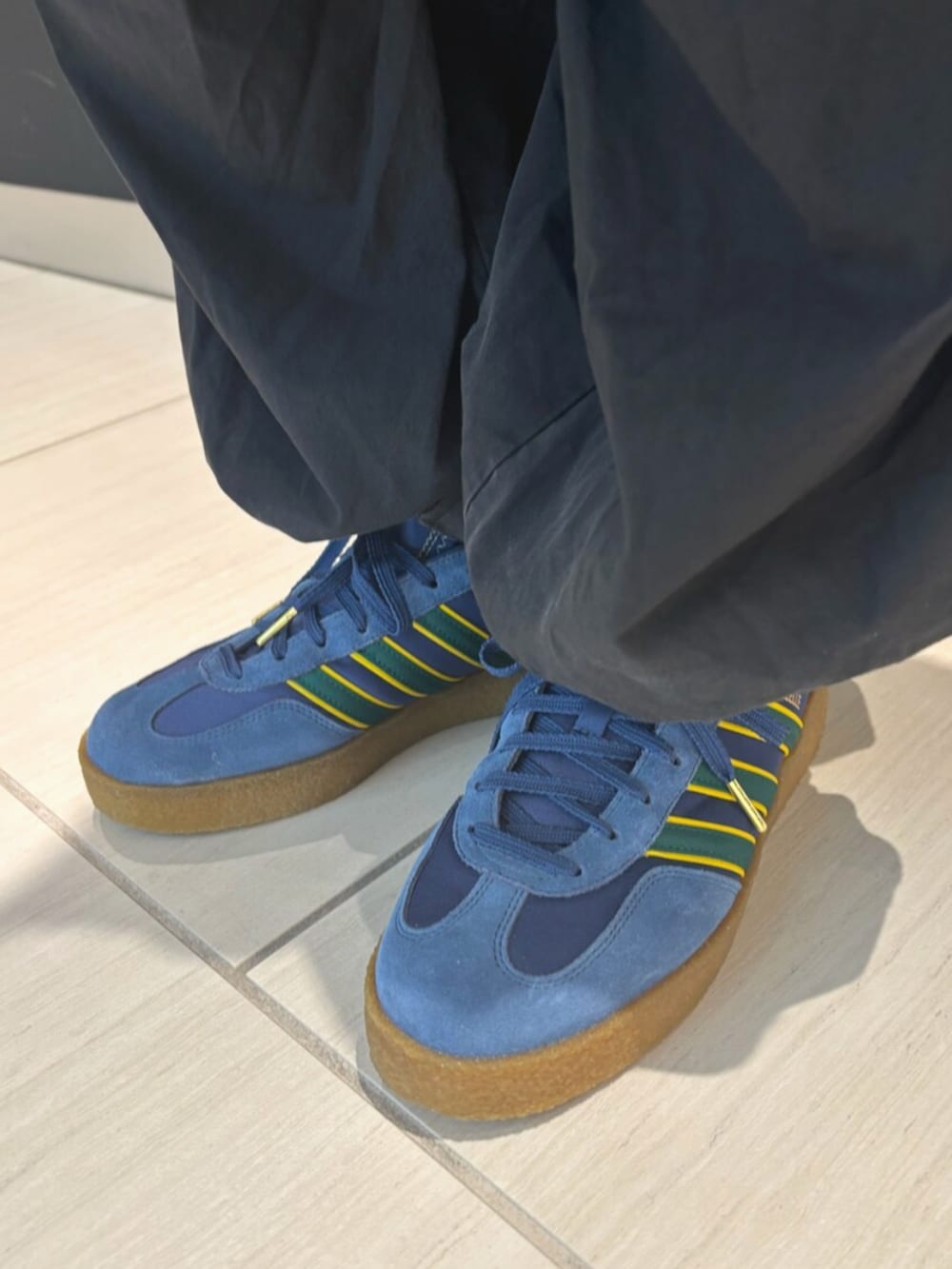 グリーン系のポロシャツ、ブルー系のシューズを着用したメンズの春コーディネートの4枚目の写真