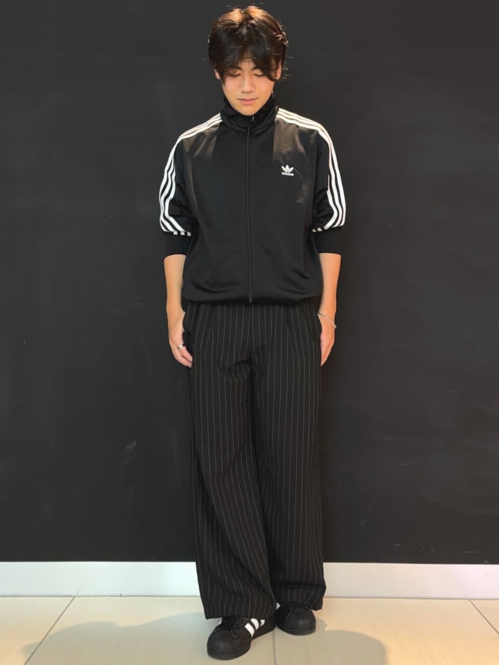 ブラック系のジャージ、ブラック系のスニーカーを着用したメンズの夏コーディネートの2枚目の写真