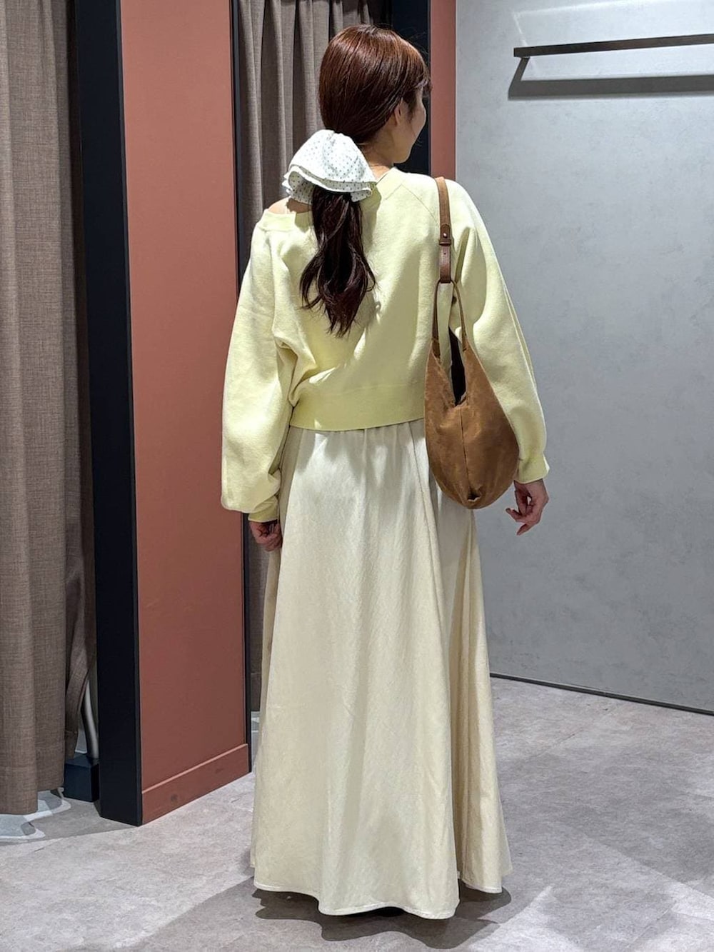 ブラック系のパンプス、ブラウン系のショルダーバッグ、イエロー系のスウェットを着用したレディースの春コーディネートの3枚目の写真