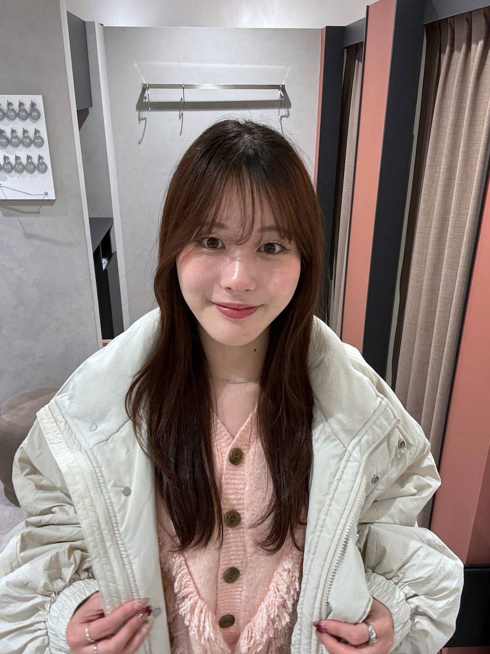 ホワイト系のその他アウター、ブラウン系のスカート、ピンク系のカーディガン/ボレロを着用したレディースの冬コーディネートの3枚目の写真