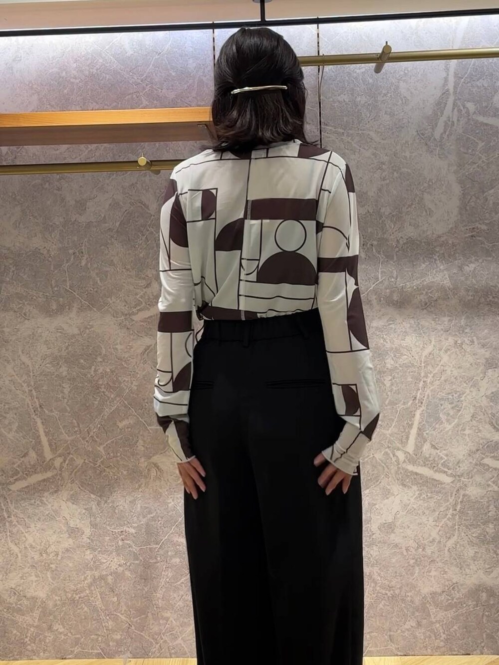 ブラック系のスラックス、ブラック系のTシャツ/カットソー、シルバー系のバレッタ/ヘアクリップを着用したレディースの秋コーディネートの4枚目の写真