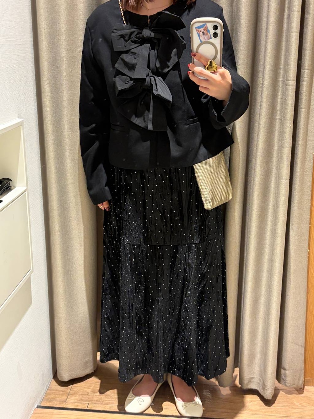 ゴールド系のショルダーバッグ、ブラック系のノーカラージャケット、ホワイト系のバレエシューズを着用したレディースの夏コーディネートの3枚目の写真