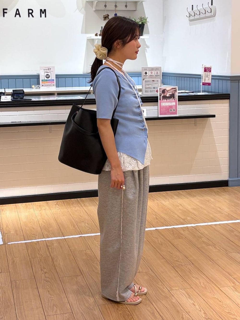 グレー系のスウェットパンツ、ブラック系のショルダーバッグ、ホワイト系のキャミソールを着用したレディースの春コーディネートの4枚目の写真