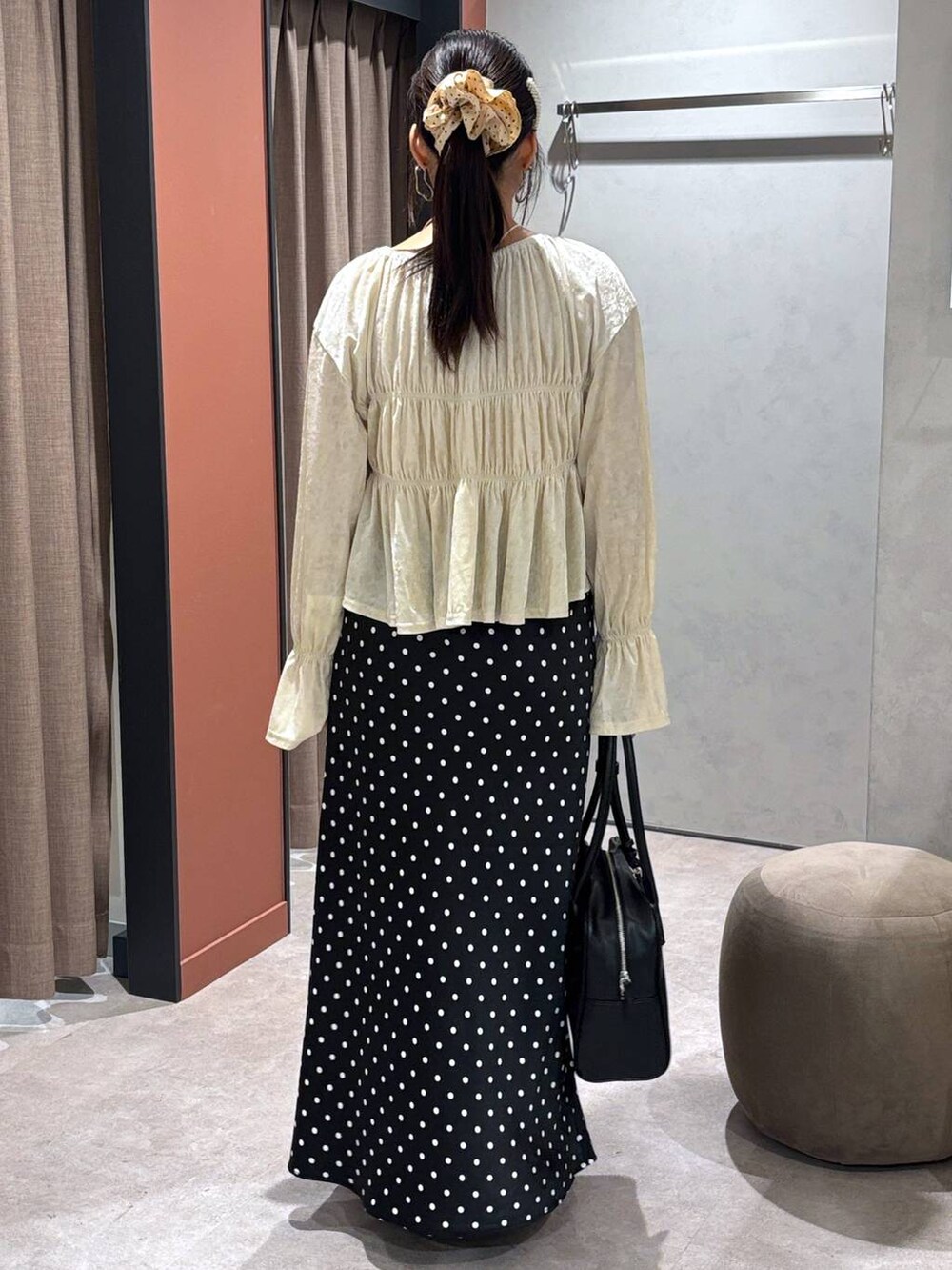 ブラック系のスカート、ブラック系のボストンバッグ、ブラック系のパンプスを着用したレディースの夏コーディネートの3枚目の写真